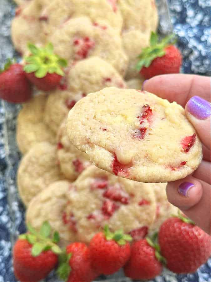 getting ready to take a bite of a strawberry sugar cookie