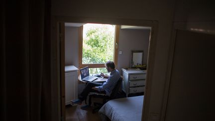 Un homme pratique le télétravail depuis son domicile. Photo d'illustration. (LOIC VENANCE / AFP)