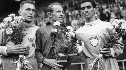 Le coureur tchécoslovaque Emil Zatopek, au centre, vainqueur du marathon olympique suivi par l'Argentin, Reinaldo Corno et le Suédois Gustaf Jansson, aux JO d'Helsinki le 27 juillet 1952 en Finlande. (KEYSTONE-FRANCE / GAMMA-KEYSTONE VIA GETTY IMAGES)