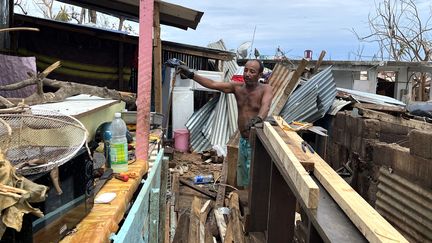 Halidi Abdallah dans les décombres de son logement, le 19 décembre 2024, à Mamoudzou (Mayotte), après le passage du cyclone Chido. (ROBIN PRUDENT / FRANCEINFO)