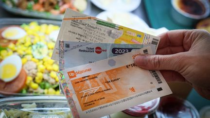 Des titres-restaurant traditionnels d'Edenred et d'UpDejeuner, utilisés par les salariés pour payer dans les restaurants ou pour acheter certains produits alimentaires dans les supermarchés depuis l'été 2022. (ALAIN JOCARD / AFP)