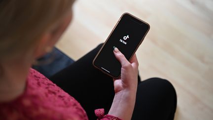 Une femme utilise l'application TikTok sur son smartphone, le 3 juillet 2024 à Berlin (Allemagne). (HELENA DOLDERER / MAXPPP)