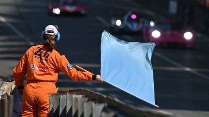 Une commissaire de course agite un drapeau bleu lors des 24 heures du Mans, le 4 juin 2023. (FRANCK DUBRAY / MAXPPP)