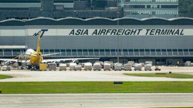 A view of the Asia Airfreight Terminal, with logo, at Hong Kong's airport. A plane is parked by the terminal, in the distance.