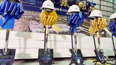 Helmets resting on shovel handles at a groundbreaking ceremony.