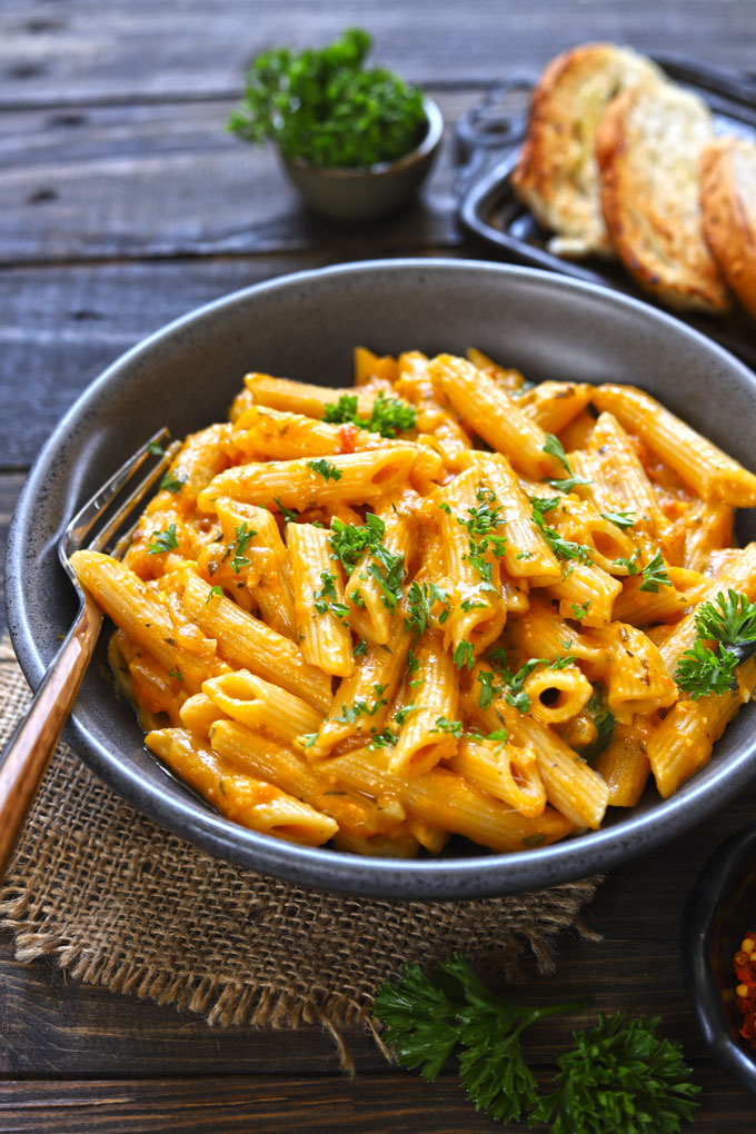 side close up shot of pumpkin pasta in a black ceramic bowl