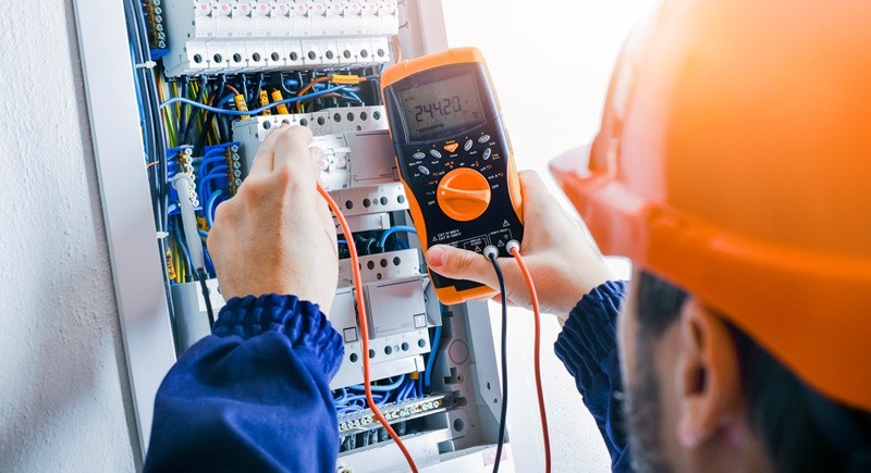 Multimeter in hands of electricians detail.