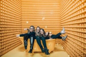 Three girls sitting on a yellow bath tub having fun