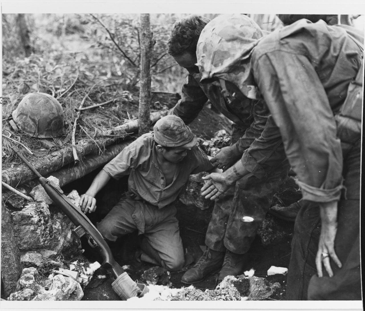 Marines coax a Japanese Navy man into surrendering on Guam in July 1944. In August 1944, a group of CHamorus were armed and trained to patrol the island and hunt for Japanese stragglers.