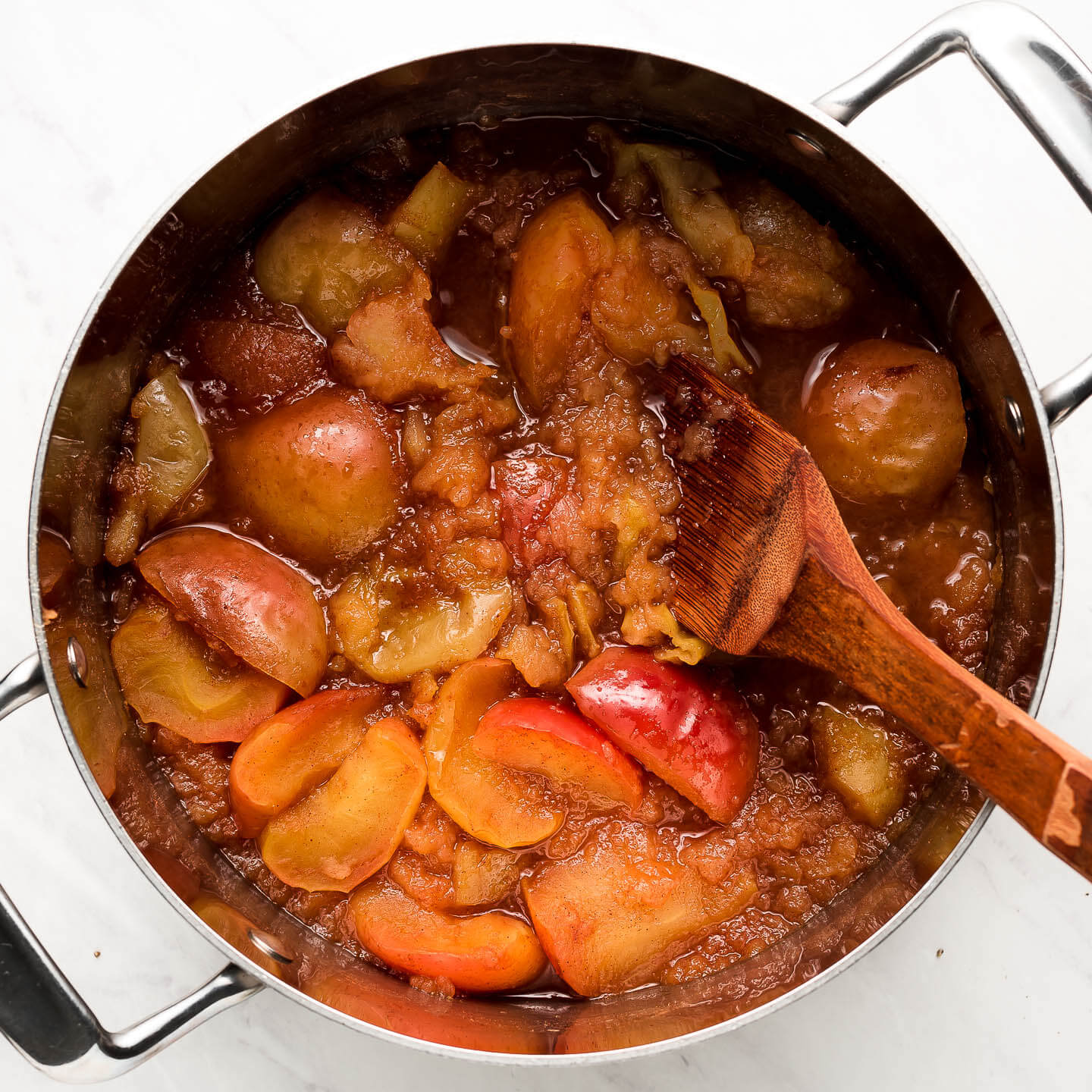 Cooked apples starting to fall apart in a pot.