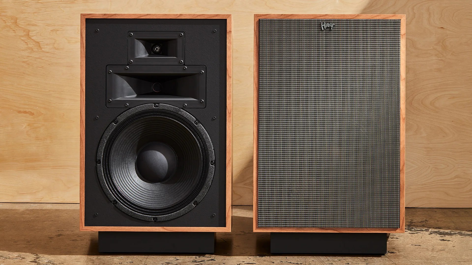 Two speakers sitting on a floor side by side