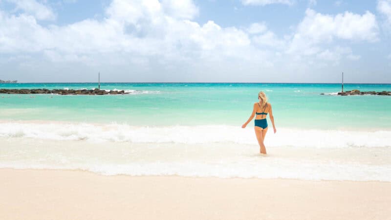 Woman walking into the ocean at the beach of Sandals Barbados Resort