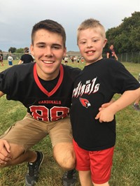 High school student playing with elementary student on playground