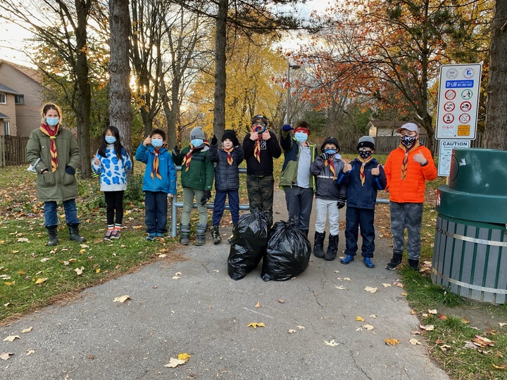 Youth stand in a park with trash picked up during a volunteer activity in Canada