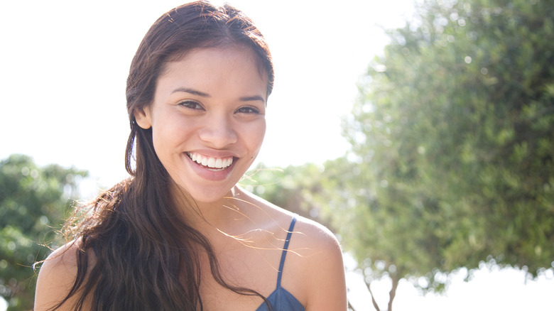 A smiling woman with long dark wavy hair.