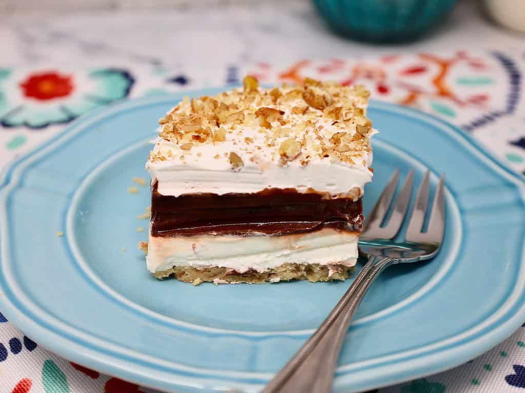 a thick slice of 4-layer delight, you can see layers of cream cheese, and chocolate pudding