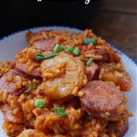 A blue trimmed white bowl with a serving of jambalaya.