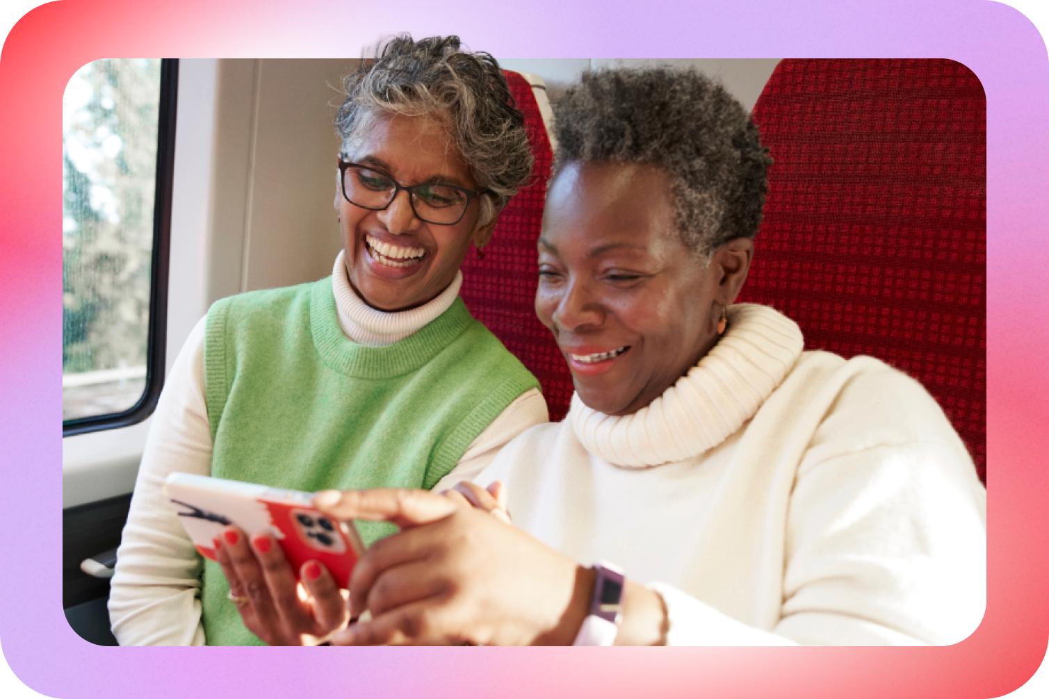 Image of two people smiling, looking at a phone screen.