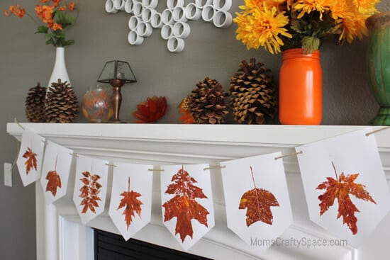 leaf stamped fall banner hanging up next to fall decorated mantel