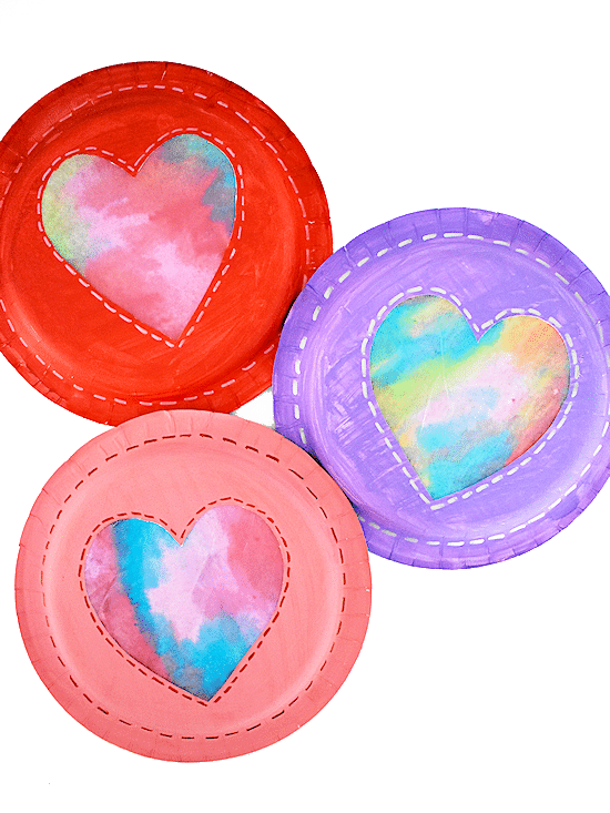 Red, purple, and pink colored paper plates with heart shape dyed coffee filter in center.