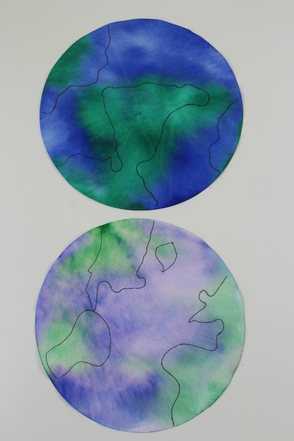 Blue and green dyed coffee filters in the shape of the earth.