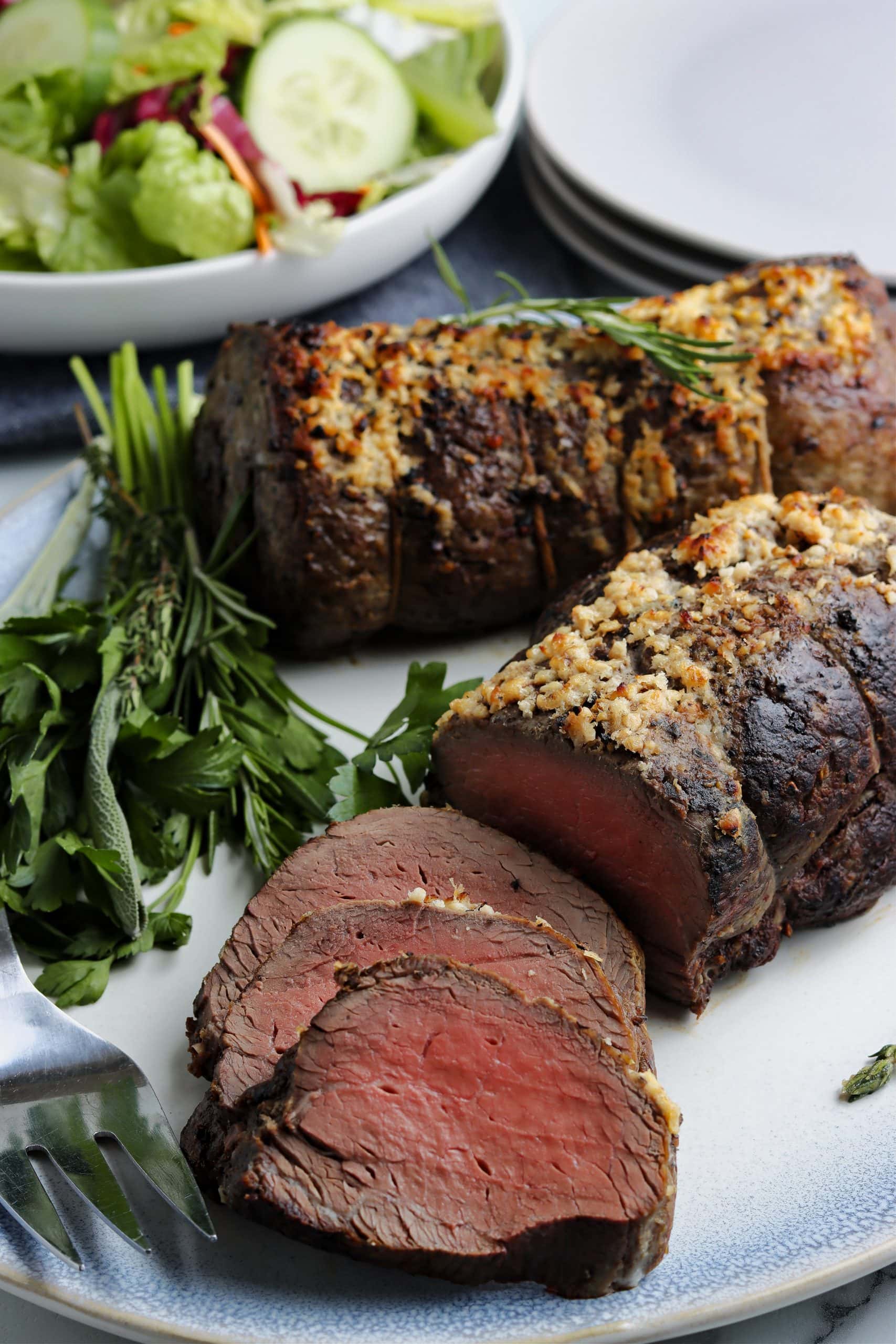 Sliced oven roast beef tenderloin on a platter.