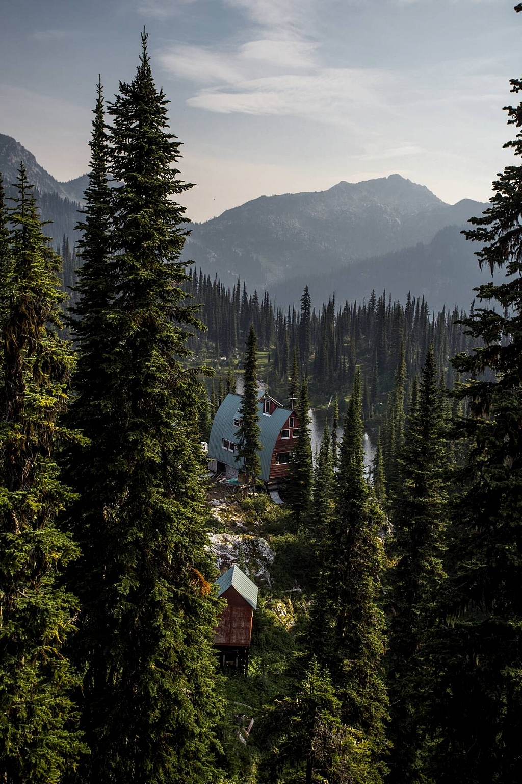 View through the trees of a secluded A-frame building