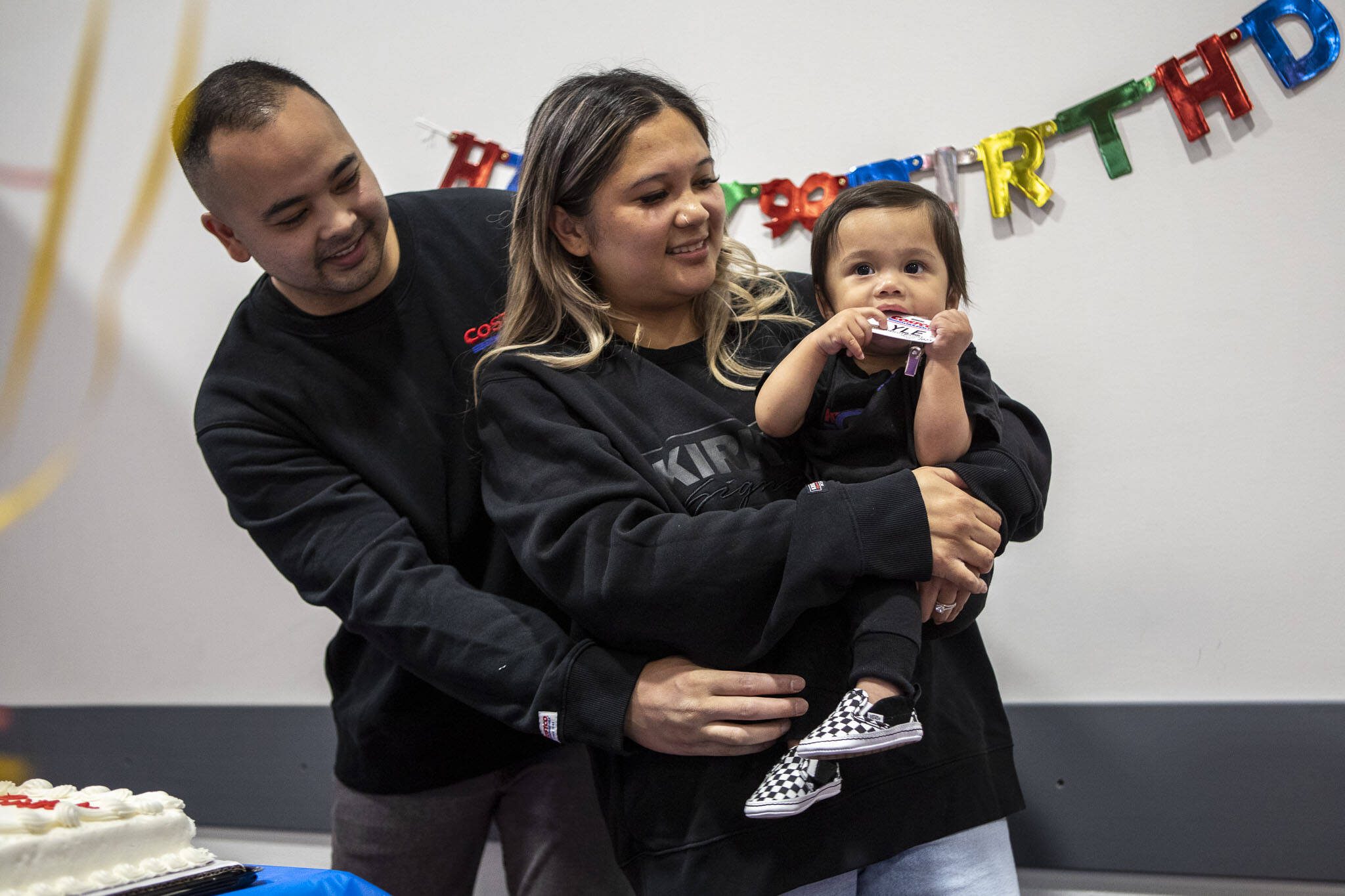 Angelo and Jona Sarmiento and their son, Carlisle, listen to “Happy Birthday” during a first birthday party at Costco in Lake Stevens on May 31. Jona’s water broke in the store a year ago. (Annie Barker / The Herald)