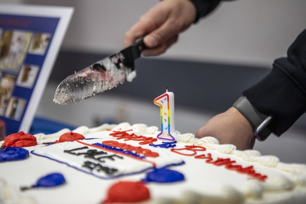 The cake is cut during a first birthday party at Costco in Lake Stevens. (Annie Barker / The Herald)
