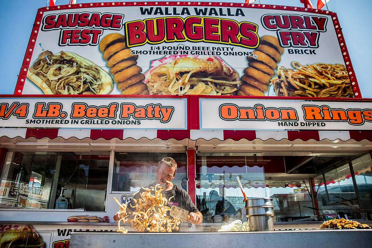 Onions are grilled up at the Walla Walla Burger booth during opening day of the Evergreen State Fair on Aug. 25, 2022 in Monroe, Washington. (Olivia Vanni / The Herald)