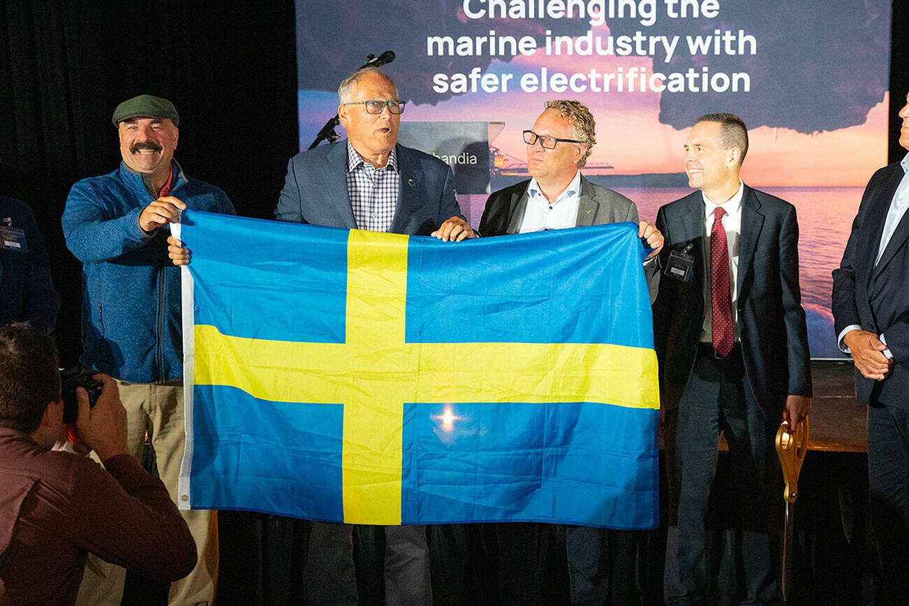 Gov. Jay Inslee presents CEO Fredrik Hellstrom with the Swedish flag during a grand opening ceremony for Sweden-based Echandia on Tuesday, July 30, 2024, in Marysville, Washington. (Ryan Berry / The Herald)