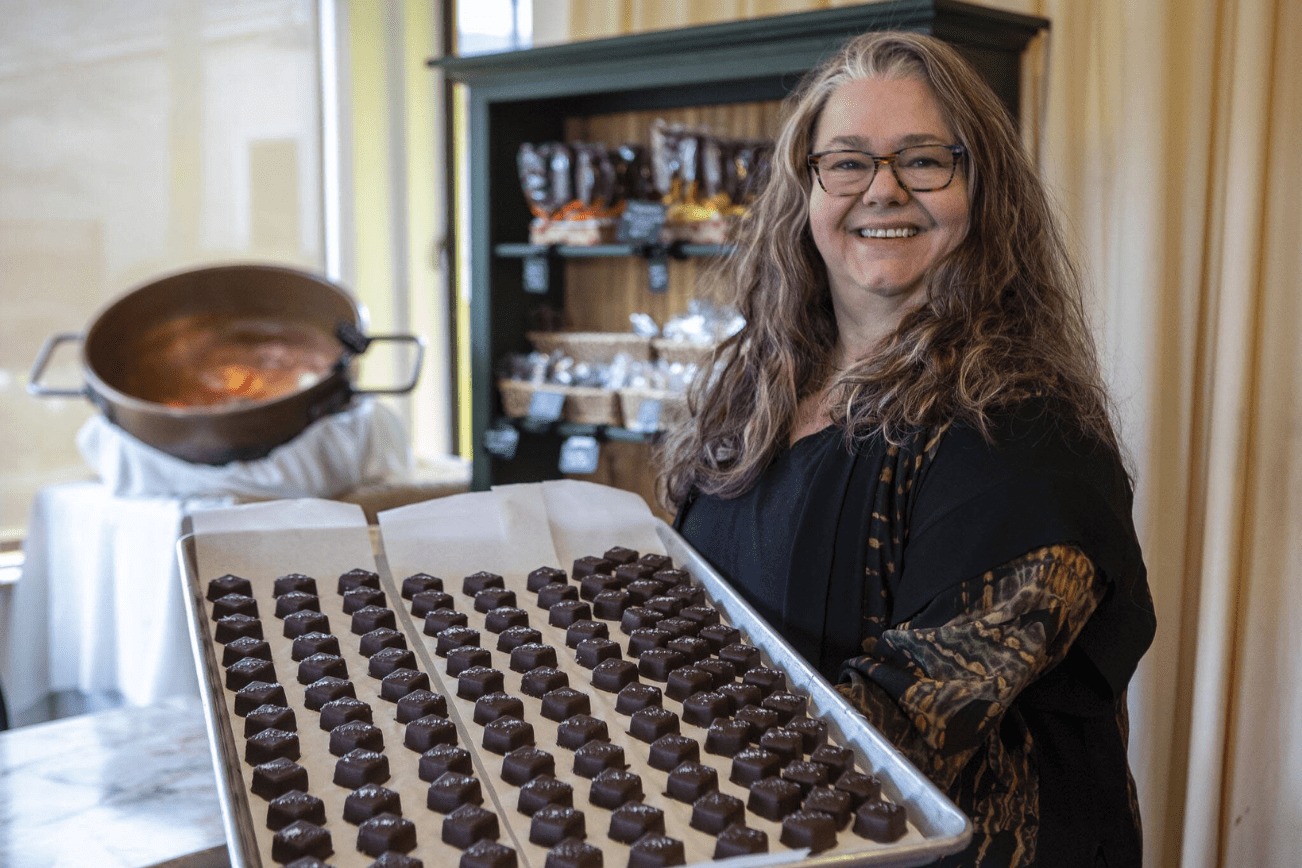 Mona Newbauer poses for a photo with caramels inside her store Sweet Mona’s Chocolates on March 21, 2024 in Langley. (Annie Barker / The Herald)