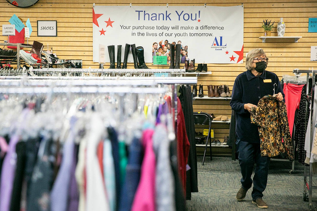 Jeanne Hoek hangs clothing on racks at the Assistance League of Everett’s Thrift Store on Monday, Dec. 2, 2024 in Everett, Washington. (Olivia Vanni / The Herald)