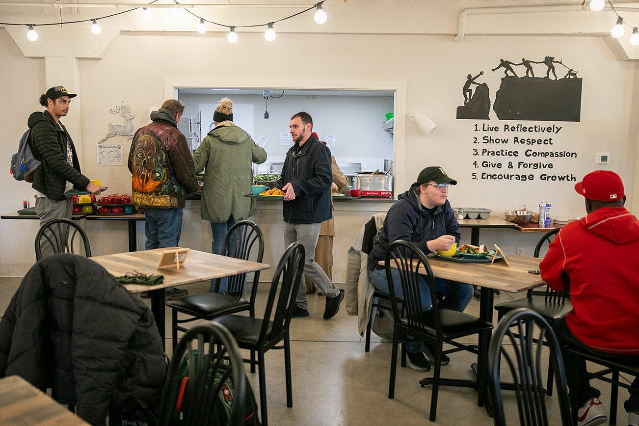 People line up to grab food at the Everett Recovery Cafe on Wednesday, Dec. 4, 2024 in Everett, Washington. (Olivia Vanni / The Herald)