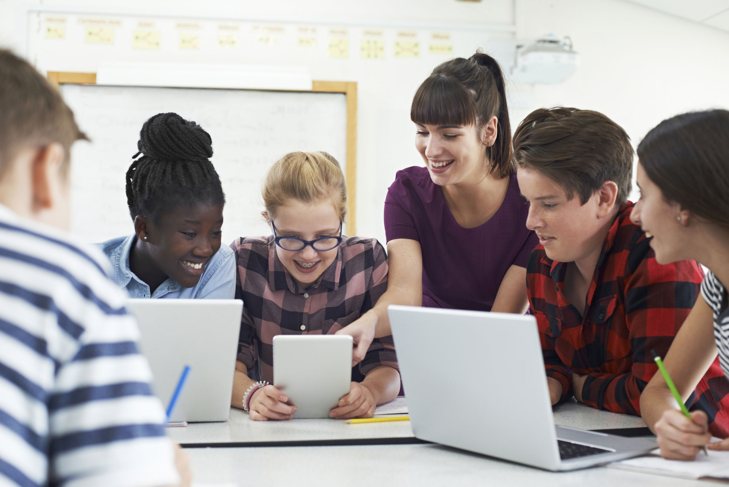 A group of students meet me in a classroom, using laptops.