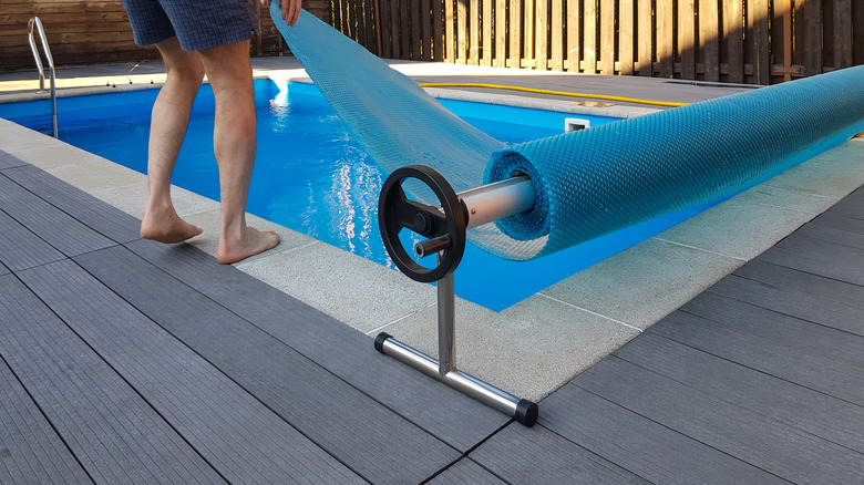 man pulls cover over pool