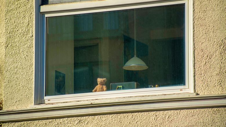 Group home window with teddy bear looking out