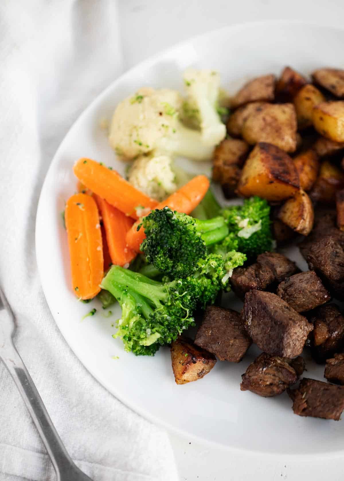 Steamed vegetables with meal on plate.