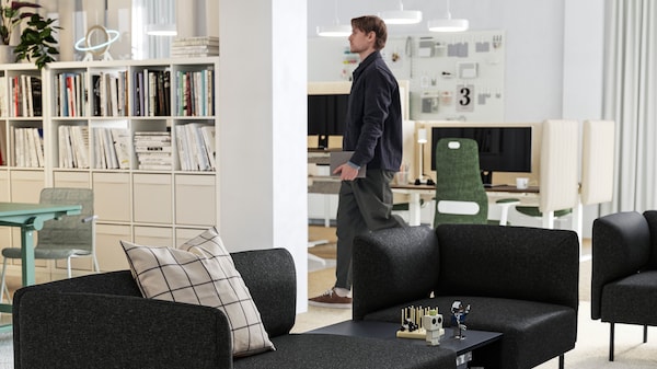 LILLEHEM 2-seat and 1-seat sofa modules in dark grey form a relaxing lounge area in a large white office.