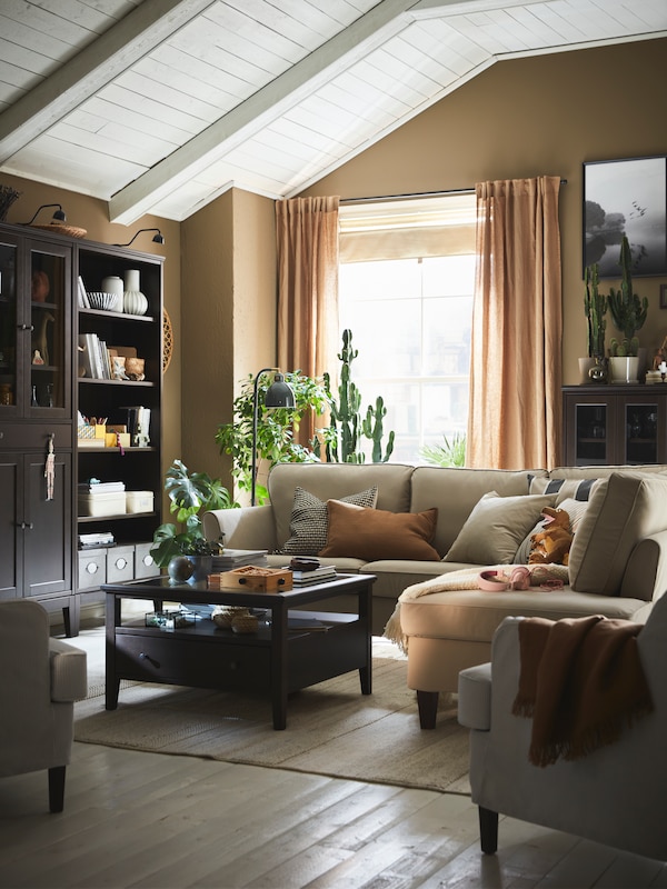 An EKHOLMA corner sofa and a dark brown stained IDANÄS coffee table stand in the centre of a traditional living room.