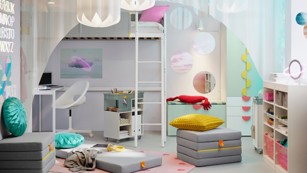 A VITVAL loft bed with desk top stands beside a SMÅSTAD/PLATSA storage combination with bench in a child’s room.