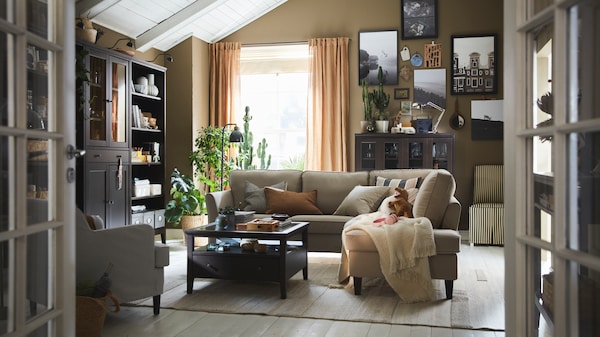 An EKHOLMA corner sofa with some extra cushions and an IDANÄS coffee table stand in the centre of a traditional living room.