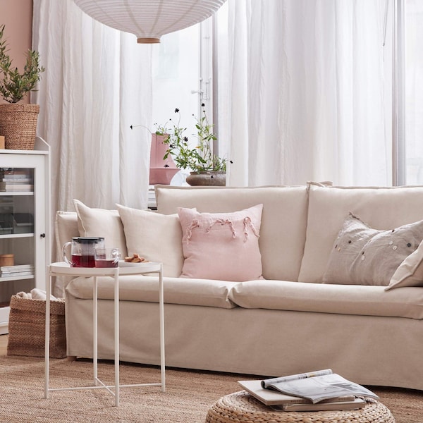 A BACKSÄLEN beige sofa in a living room.