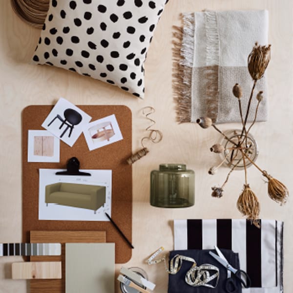 A moodboard with images of furniture laid out on a SUSIG cork deskpad beside a cushion, two glass vases and colour samples.