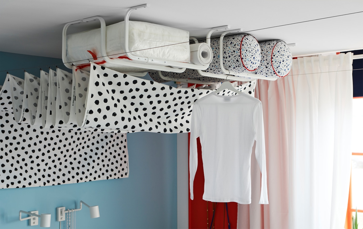 Several white MULIG clothes bars mounted onto the ceiling for storage and for drying laundry.