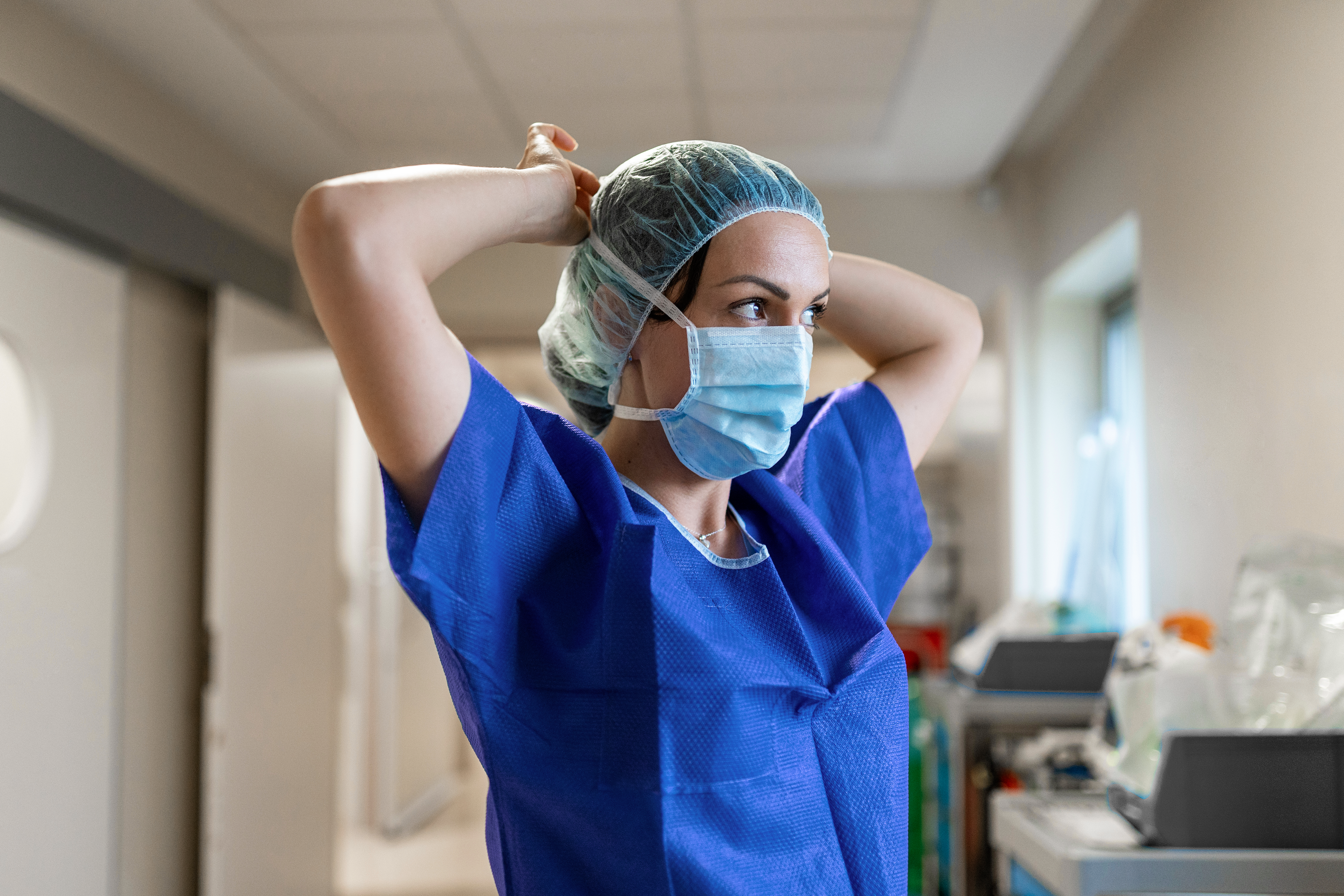 Nurse putting on her mask