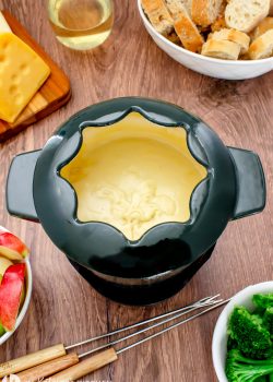 fondue pot with cheese, vegetables and bread on a table