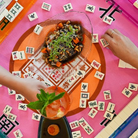 Mahjong tiles spread out on a pink and orange table