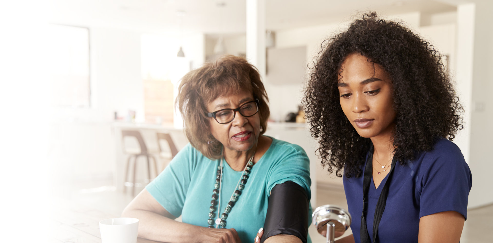 caregiver check the blood pressure of her patient