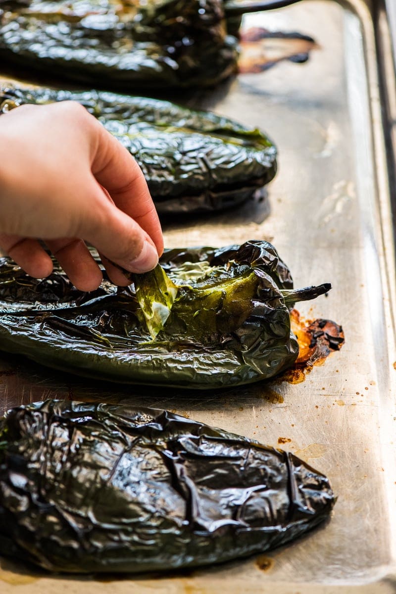 Puxar a pele dos pimentos poblanos assados